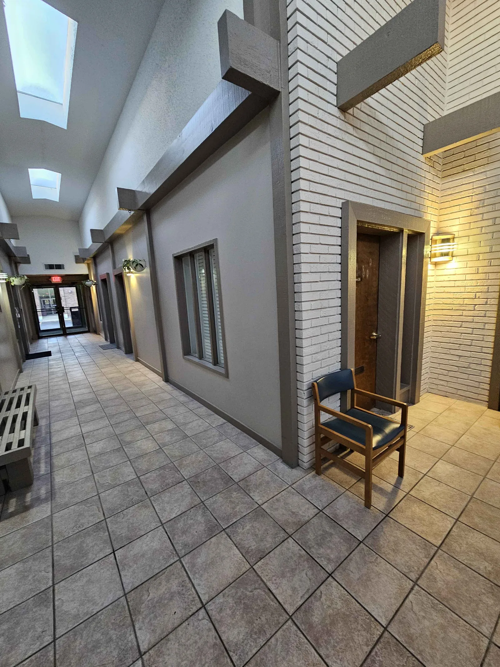 Professional hallway with brick walls, skylights, and suite entrances at 10000 Watson Rd Crestwood MO